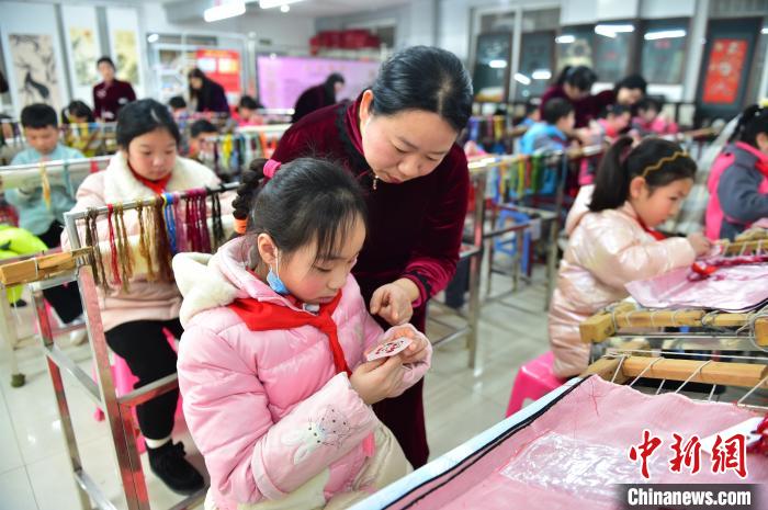 江西省級非遺豫章繡傳承人手把手指導小學生繡制2022年北京冬奧會吉祥物“冰墩墩”形象?！∮髟屏?攝