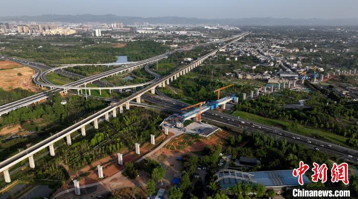 航拍正在建設的跨越成都繞城高速公路連續梁施工現場，旁邊依次為已運營的成渝高速鐵路和機場高速公路。　劉忠俊 攝