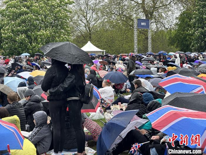 當(dāng)?shù)貢r(shí)間5月6日，英國國王查爾斯三世的加冕儀式舉行。民眾雨中觀看儀式。　歐陽開宇 攝