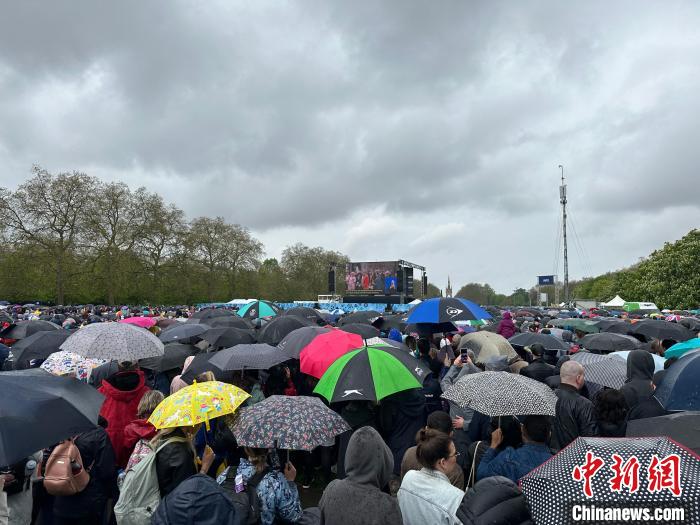 當(dāng)?shù)貢r(shí)間5月6日，英國國王查爾斯三世的加冕儀式舉行。民眾雨中觀看儀式。　歐陽開宇 攝