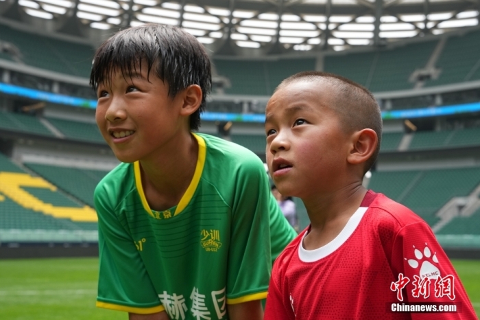 圖為北京國安小球員陳小北和7歲的俄金仁增在一起觀看場內播放的紀錄片。<a target='_blank' href='/' _fcksavedurl='/'><p  align=