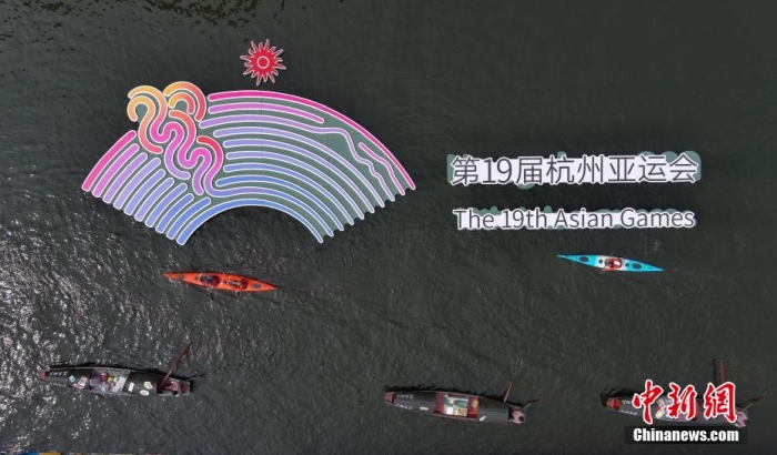 資料圖為烏篷船和皮劃艇從杭州亞運會標識前劃過。王剛 攝