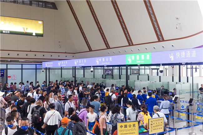 7月22日，乘坐中老鐵路國(guó)際旅客列車的旅客在磨憨邊檢大廳排隊(duì)候檢。衛(wèi)海林 攝