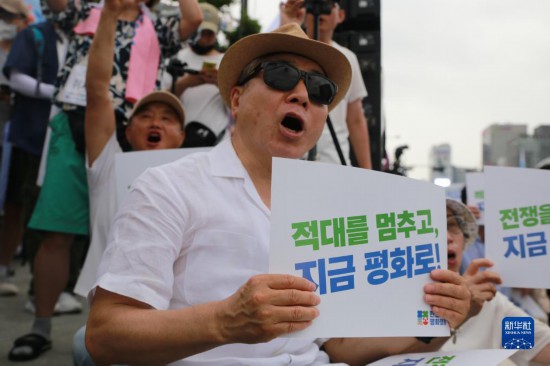 7月22日，在韓國首爾，人們手舉標語參與反戰游行。新華社發（楊暢 攝）