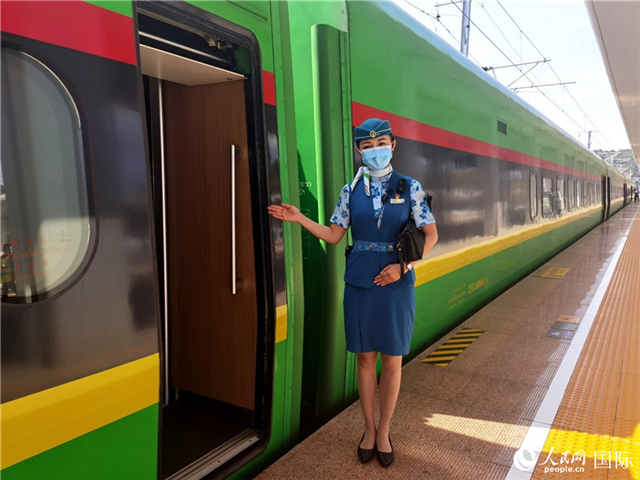 趙瑩靜站在“復興號”國際旅客列車車廂門口歡迎旅客上車。人民網 杜明明攝