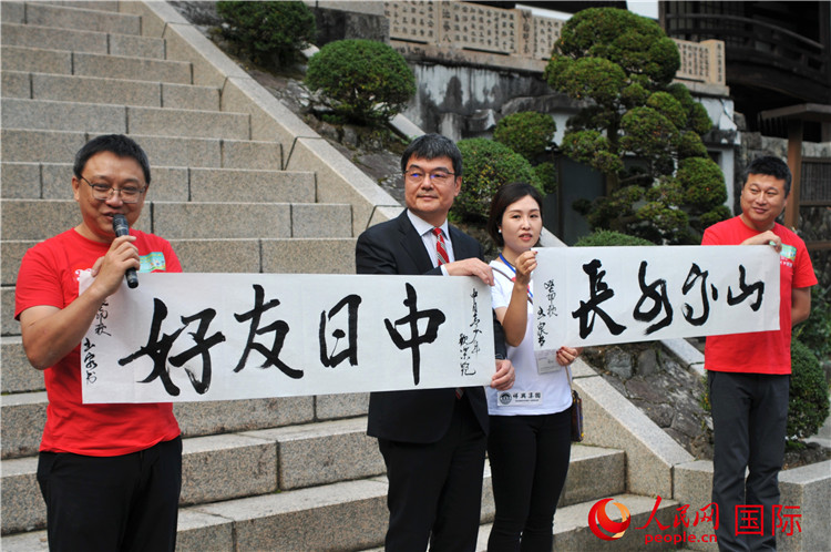 東京中國文化中心主任羅玉泉展示其為本次活動書寫的題詞“中日友好，山高水長”。人民網(wǎng) 蔣曉辰攝