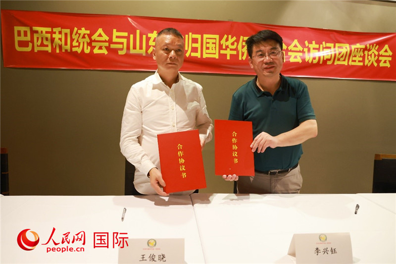 中國僑聯(lián)副主席、山東省僑聯(lián)主席李興鈺（右）與巴西和統(tǒng)會會長王俊曉簽署合作協(xié)議書。人民網(wǎng)記者 陳海琪攝