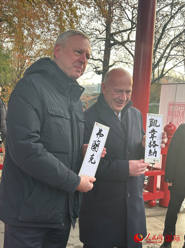 柏林市長(zhǎng)韋格納（右）、動(dòng)物園監(jiān)事會(huì)主席布魯克曼（左）手持中國(guó)文化中心工作人員現(xiàn)場(chǎng)手書(shū)的中文名字。人民網(wǎng)記者 徐馨攝