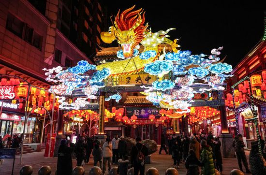 2月11日，游客在沈陽中街游覽。春節(jié)期間，各地?zé)艋痂病⒒饦溷y花，呈現(xiàn)出一幕幕流光溢彩的視覺盛宴。（新華社記者潘昱龍攝）