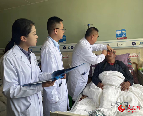 董光明（左三）帶領(lǐng)醫(yī)生對(duì)患者進(jìn)行術(shù)前檢查。人民網(wǎng)記者 杜燕飛攝