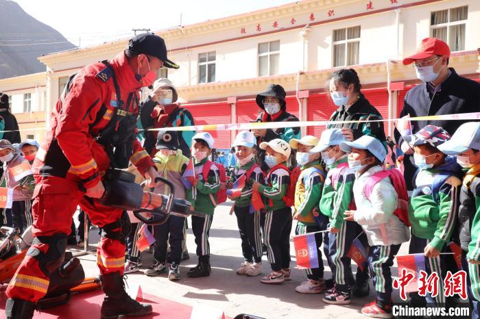 圖為消防指戰員為學生講解、演示先進救援裝備?！≮w琳 攝