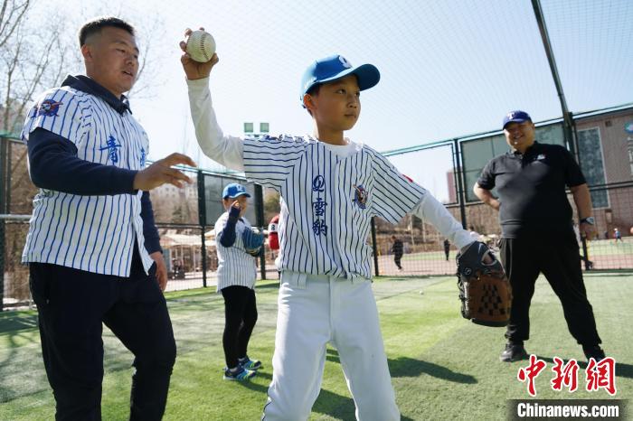 圖為教練指導(dǎo)小棒球手?jǐn)S球技術(shù)?！●R銘言 攝