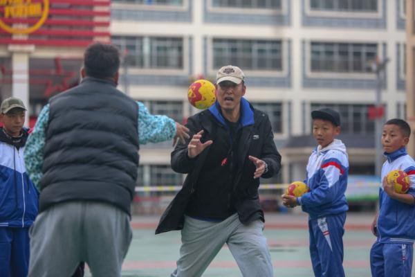在高原上教孩子們打手球，“慢慢兒來，甭著急！”