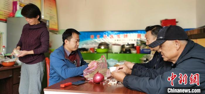 圖為扶貧路上“臨時一家人”準備午餐。　魏建軍 攝