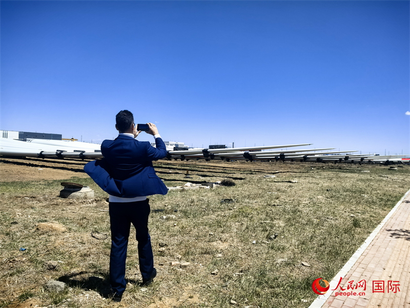 外媒記者拍攝廠房外的風力渦輪發(fā)電機的巨型漿葉。人民網(wǎng) 楊春燕攝