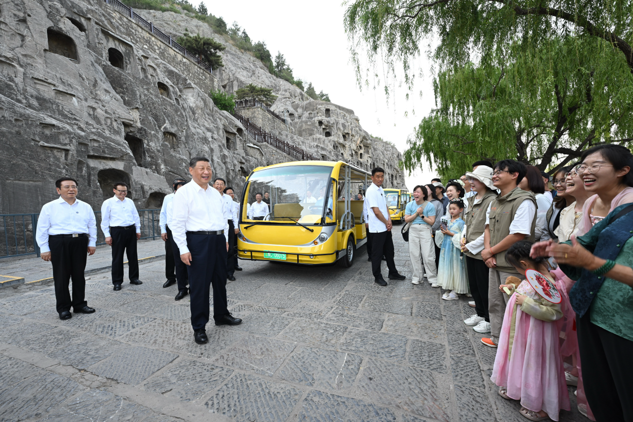 5月19日，習近平在洛陽龍門石窟考察時，同游客親切交流。
