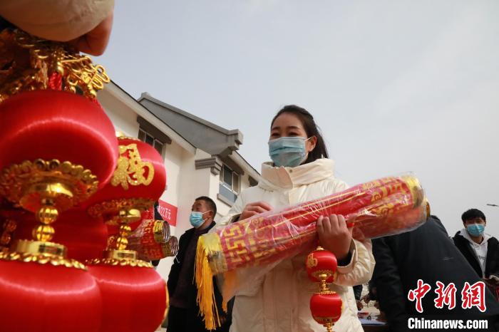 27日，蘭州新區為舟曲避險搬遷移民送“春節包”，楊周馬草前往領取，紅色寓意來年的日子紅紅火火。　魏建軍 攝