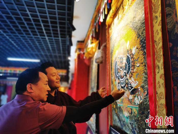 圖為久美尖措展示唐卡作品。　張?zhí)砀?攝