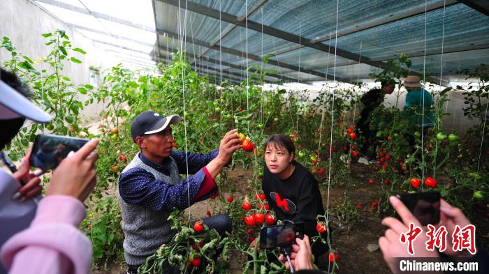 圖為群培(左)為青年職工進行技術指導。　張偉 攝